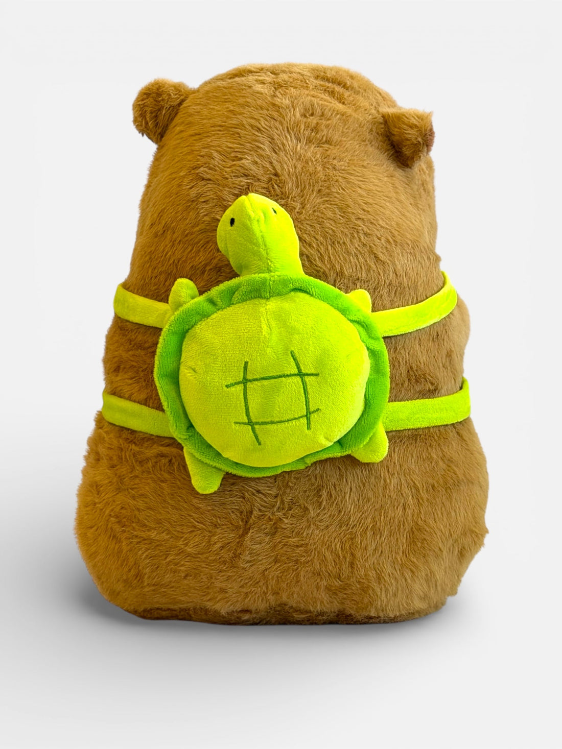 Capybara plush toy wearing a turtle backpack