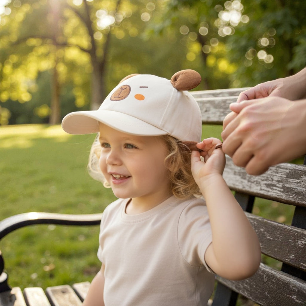 Child wearing a white cap with a Capybara in a park setting