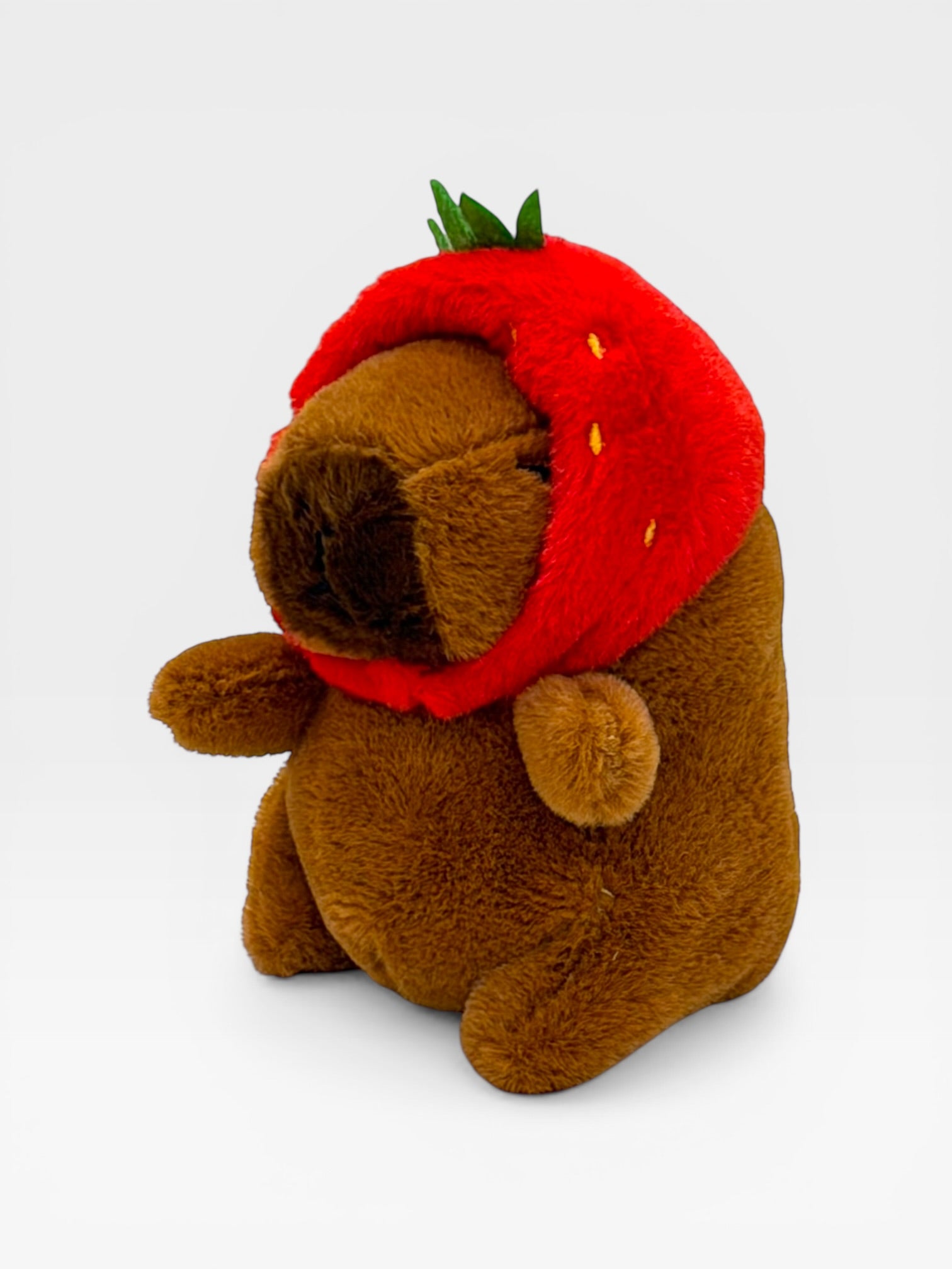 Plush toy Capybara wearing a red strawberry costume 