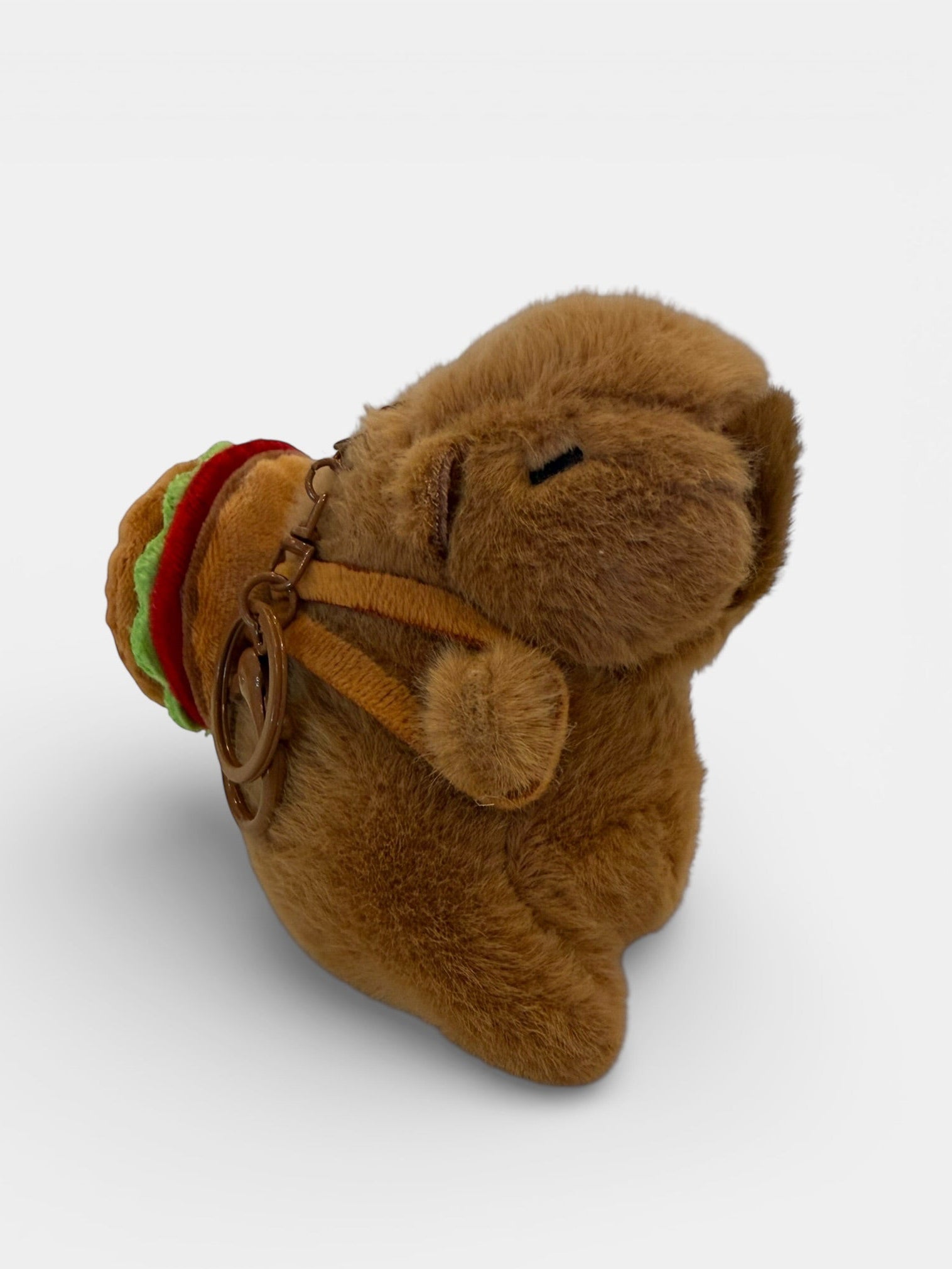 Plush toy resembling a bear with a backpack on a white background