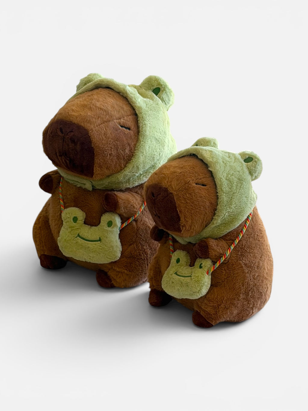 Two plush Capybaras with frog hats and purses