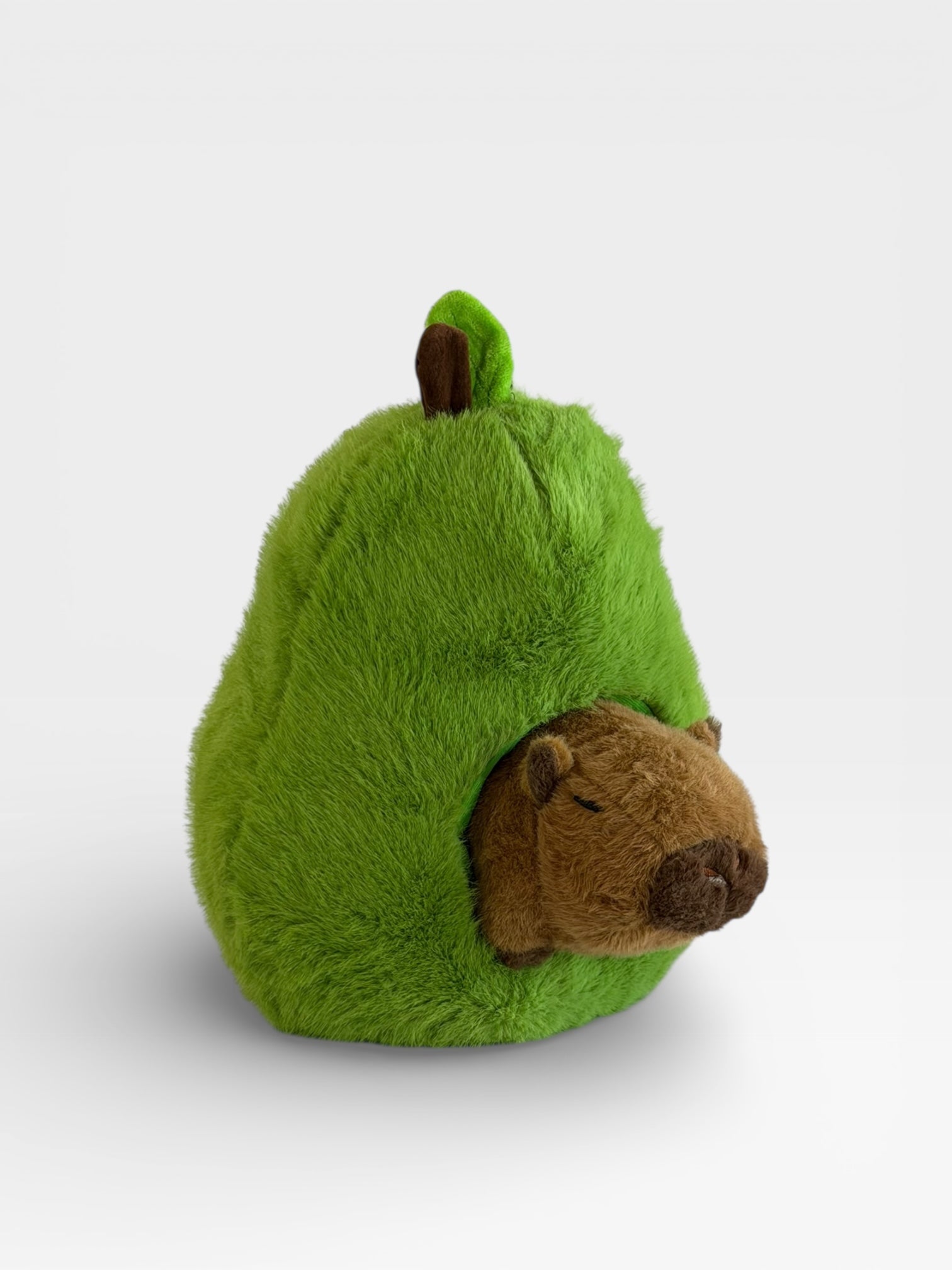 Green plush toy shaped like a pear with a Capy plush