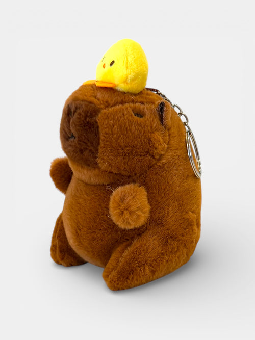 Plush bear keychain with a yellow duck on its head against a white background