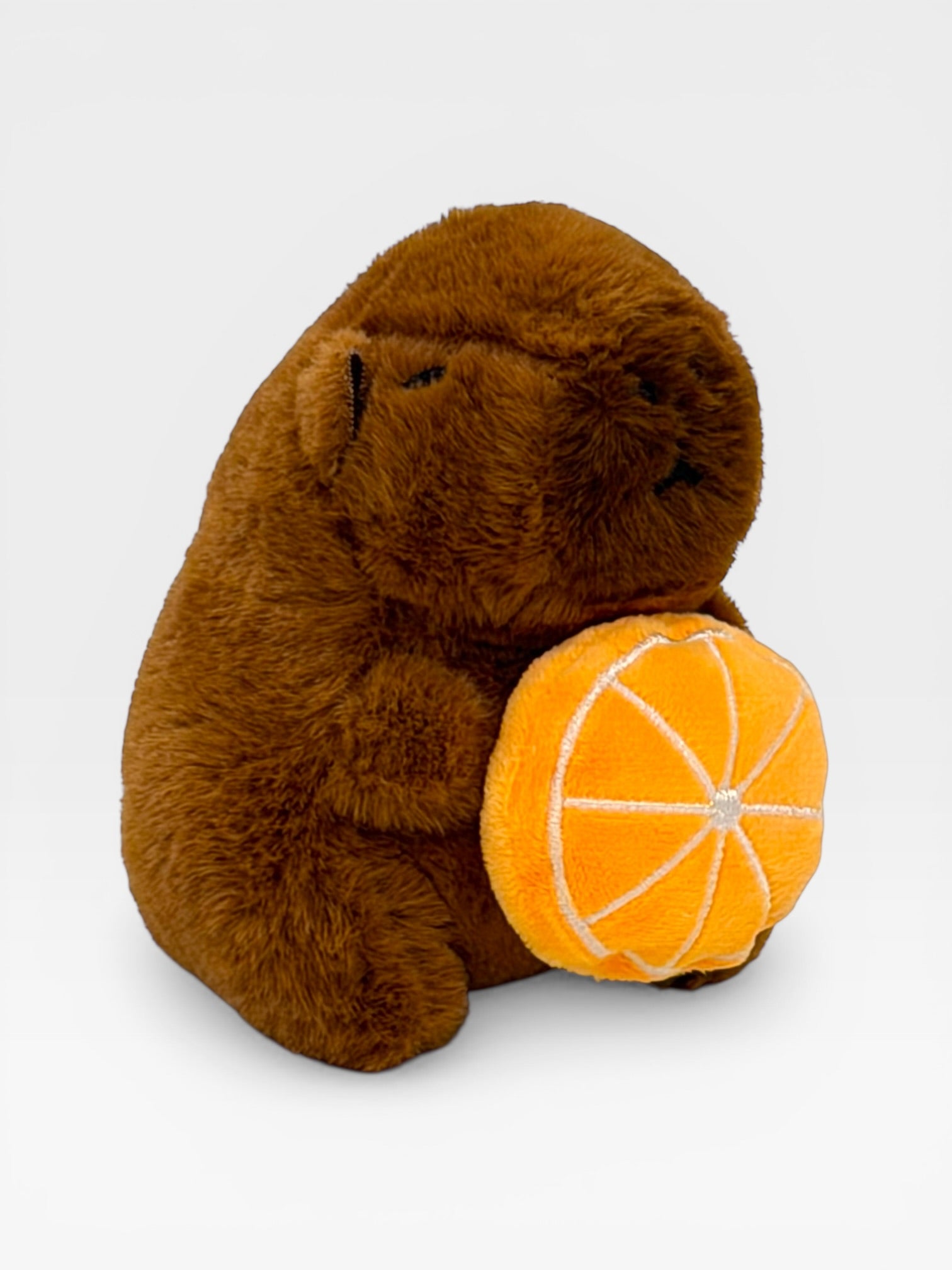 Plush Capybara holding a toy orange ow