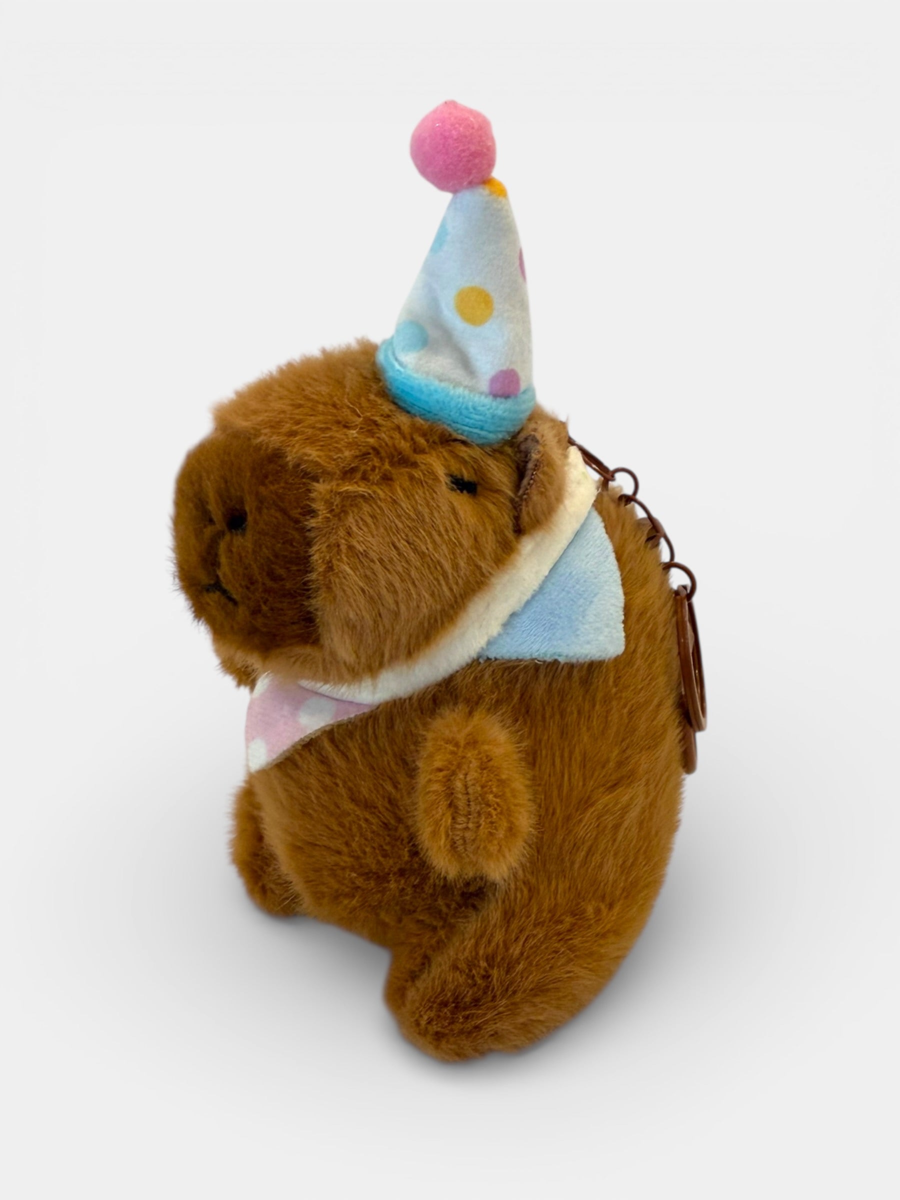 Plush Capybara wearing a party hat on a white background