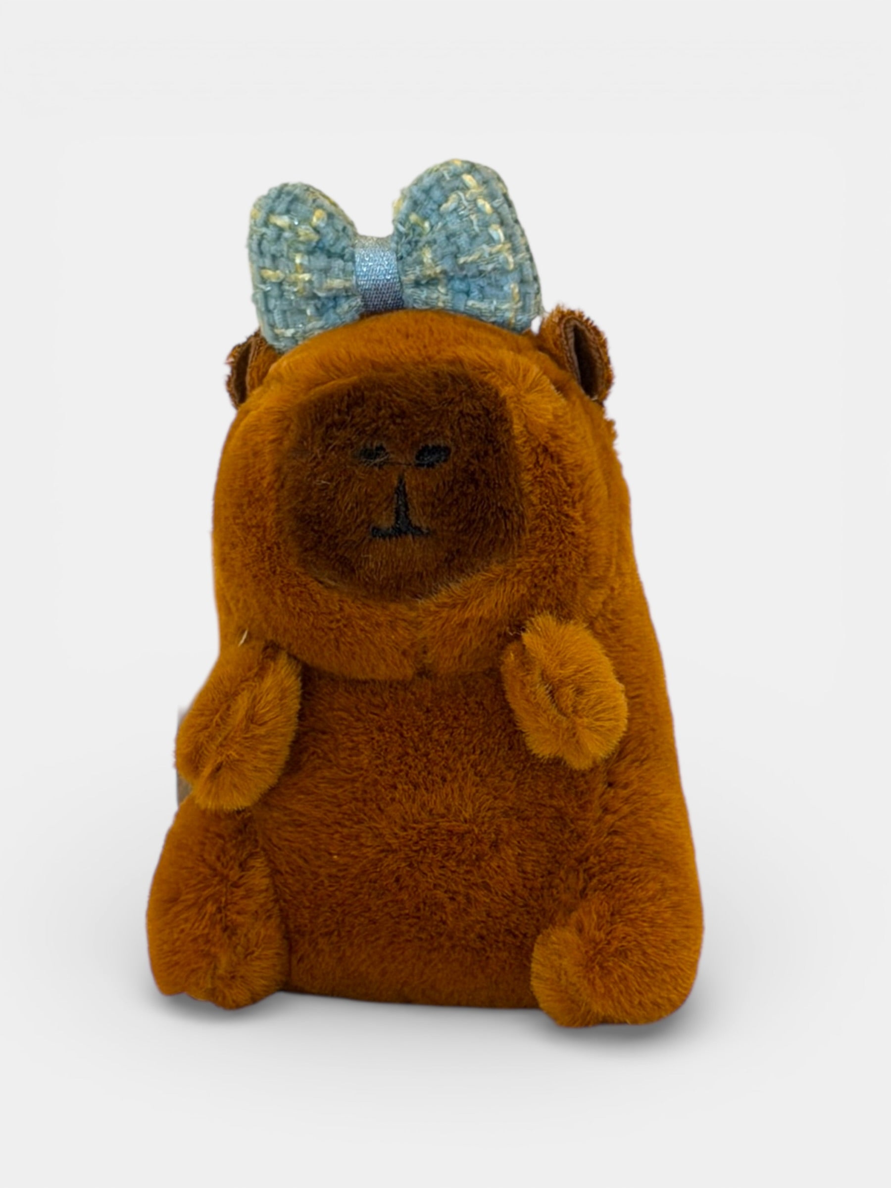 Brown Capybara with a blue bow on a white background