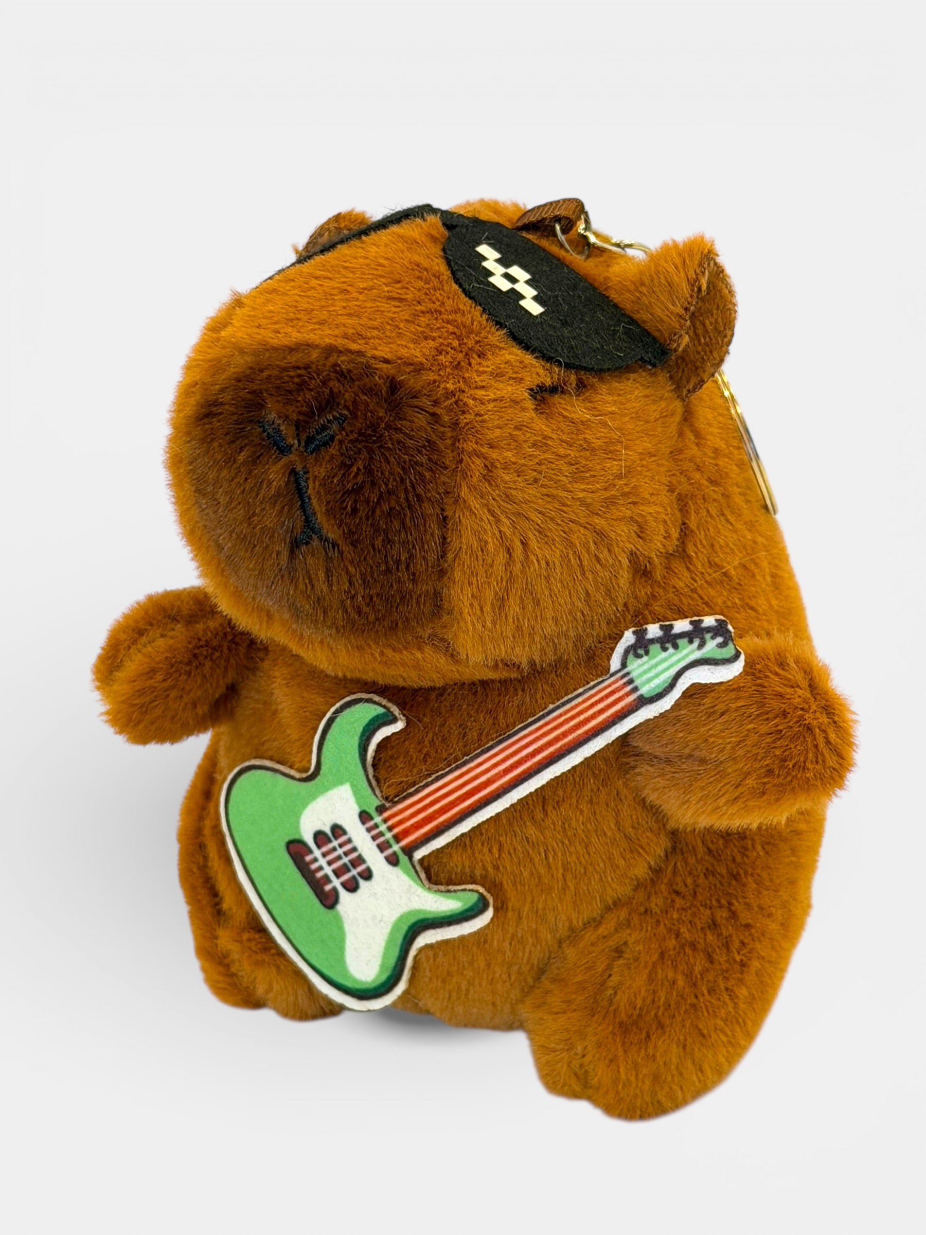 Plush bear toy with a green electric guitar on a white background