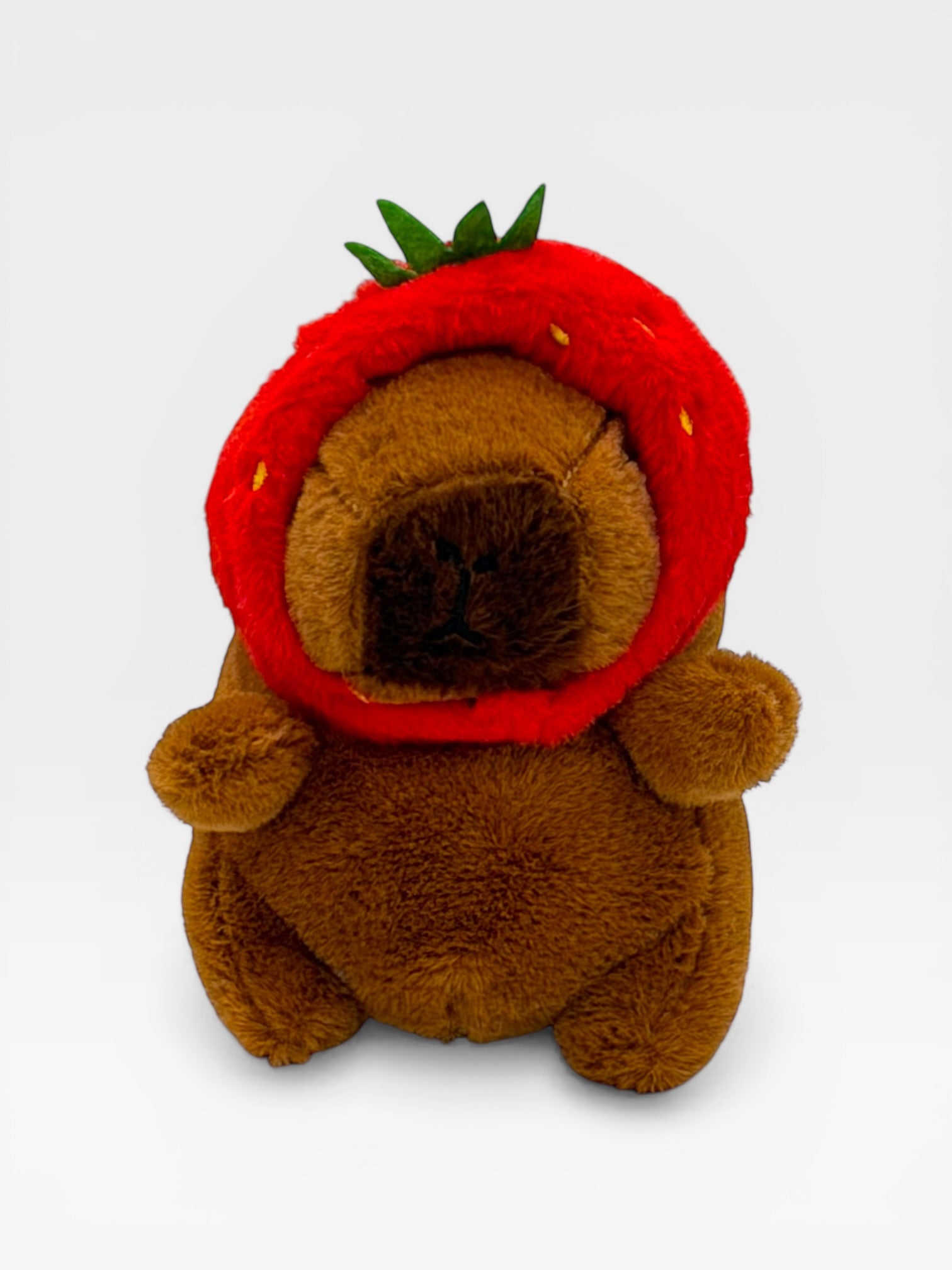 Plush toy resembling a Capybara wearing a red strawberry hat