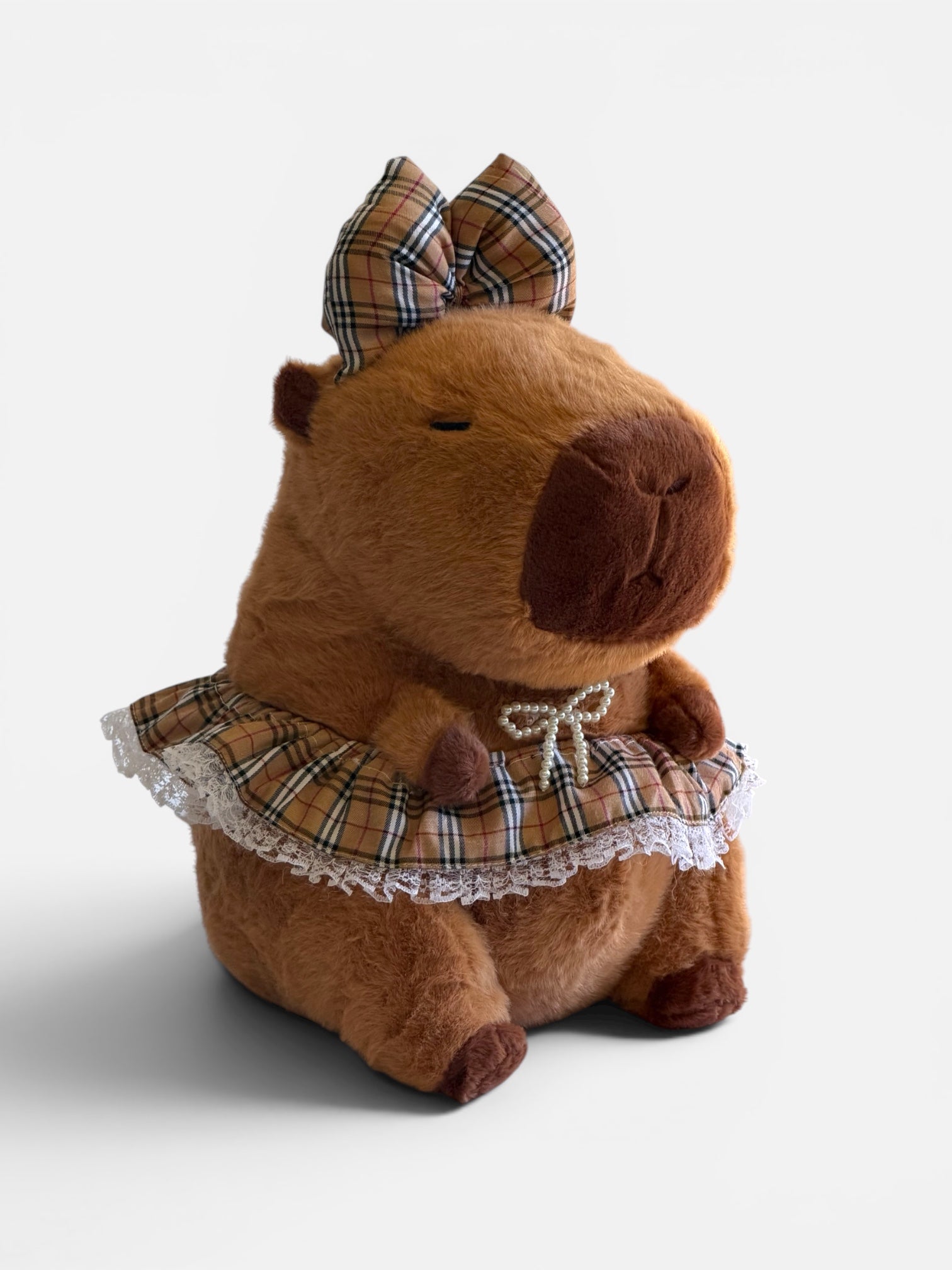 Capybara wearing a plaid dress and bow 